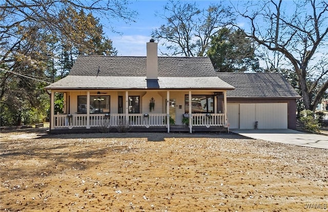 farmhouse with roof with shingles, a chimney, covered porch, concrete driveway, and an attached garage