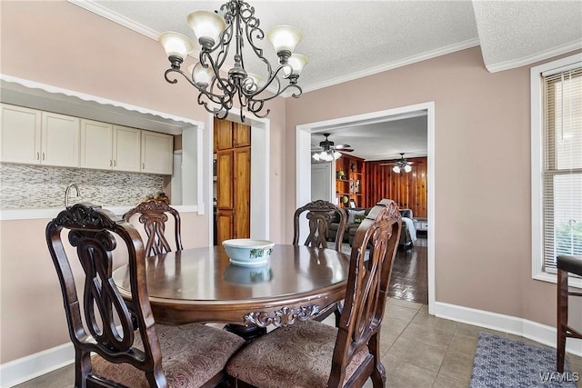 dining area featuring a textured ceiling, ornamental molding, tile patterned flooring, and a healthy amount of sunlight