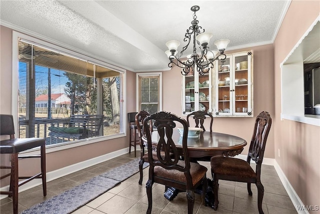 dining space featuring an inviting chandelier, crown molding, tile patterned floors, and a textured ceiling