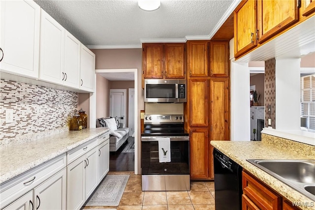 kitchen featuring crown molding, stainless steel appliances, backsplash, white cabinets, and a sink