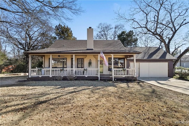 view of front of home featuring roof with shingles, a chimney, a porch, an attached garage, and driveway