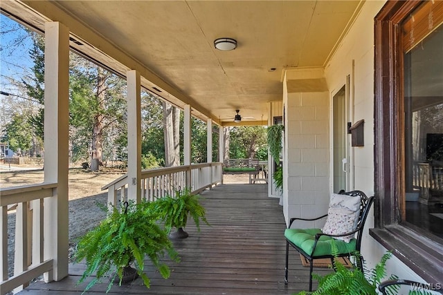 wooden terrace with ceiling fan and covered porch