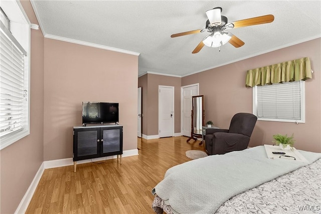 bedroom with ornamental molding, light wood-type flooring, a textured ceiling, and ceiling fan