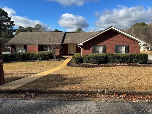 single story home featuring a front yard and brick siding