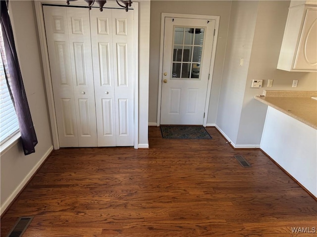 doorway to outside with dark hardwood / wood-style flooring and a notable chandelier