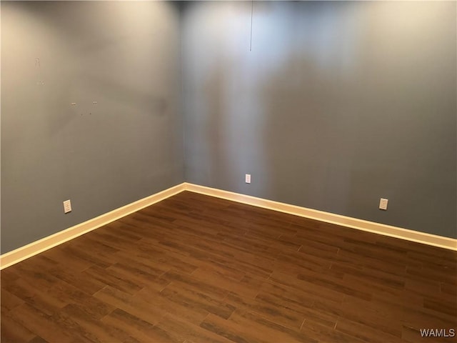 empty room with dark hardwood / wood-style flooring