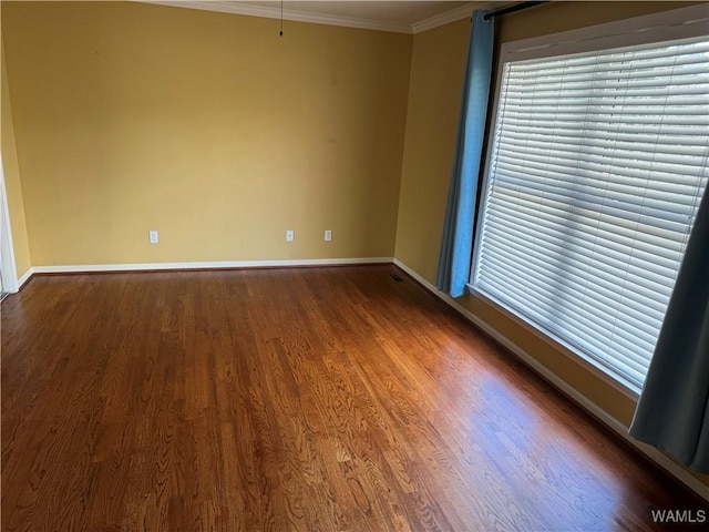 spare room with hardwood / wood-style flooring and crown molding