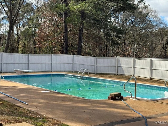 view of swimming pool featuring a diving board