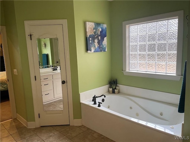 bathroom with a tub with jets, tile patterned flooring, and vanity