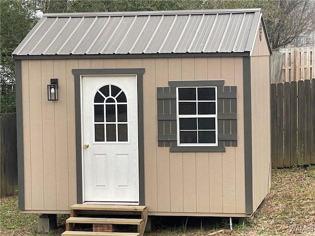 view of shed with entry steps and fence