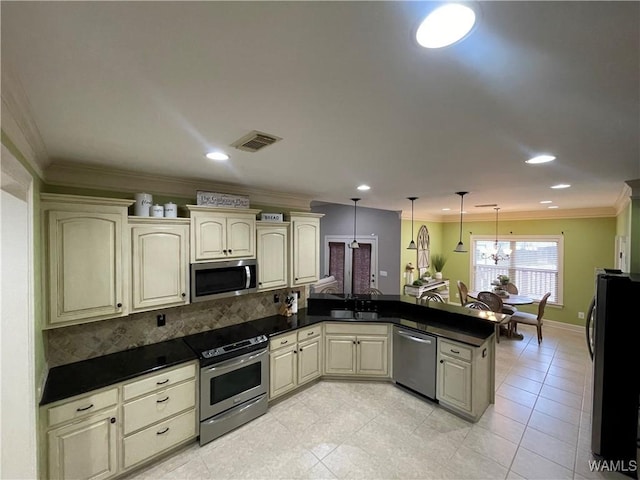 kitchen featuring a peninsula, appliances with stainless steel finishes, visible vents, and crown molding