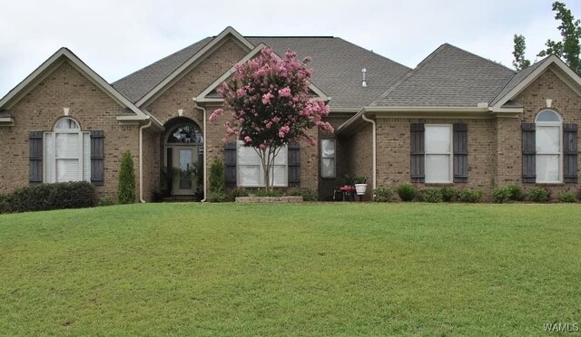 single story home with a garage, driveway, brick siding, and a shingled roof