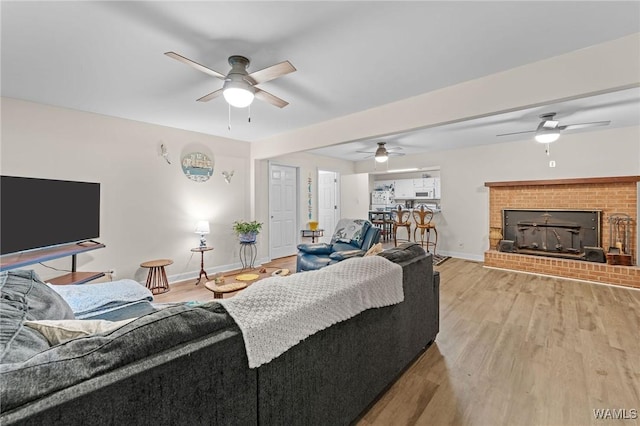 12515 Bone Camp Rd, Northport, AL 35475 - living area with a ceiling fan, baseboards, a fireplace, and light wood finished floors