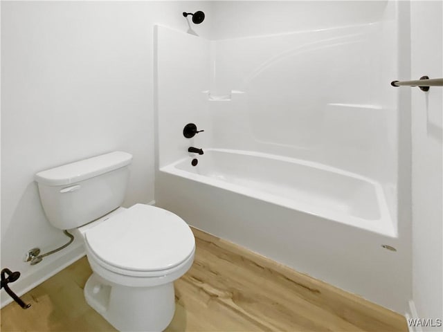 bathroom with tub / shower combination, toilet, and wood finished floors