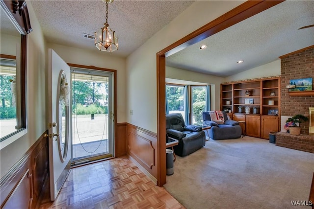3541 Oak Bend Rd, Tuscaloosa, AL 35406 - entrance foyer with a textured ceiling, plenty of natural light, a wainscoted wall, a chandelier, and a brick fireplace