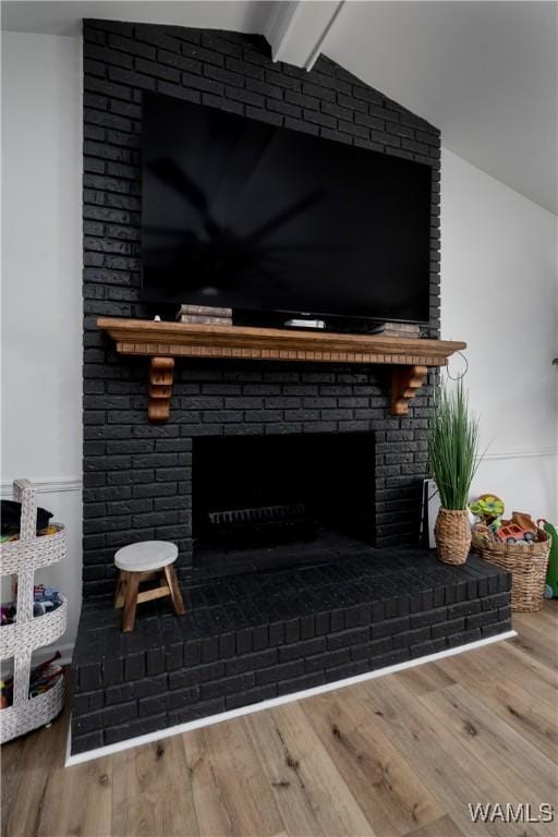 details with wood finished floors, a fireplace, and beam ceiling