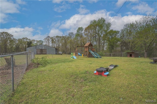 view of yard with an outbuilding, fence, a playground, and a pole building