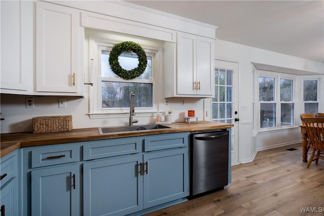 kitchen with dishwasher, a sink, light wood-style floors, wood counters, and blue cabinets