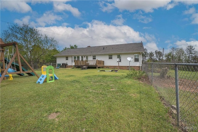 rear view of house featuring a deck, a yard, a fenced backyard, and a playground