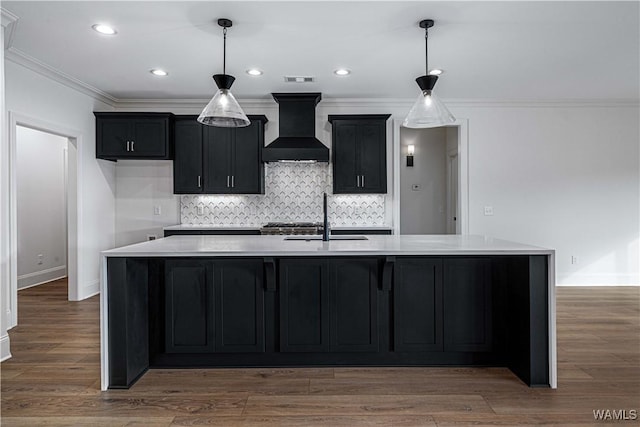 kitchen featuring a kitchen island with sink, sink, and custom exhaust hood