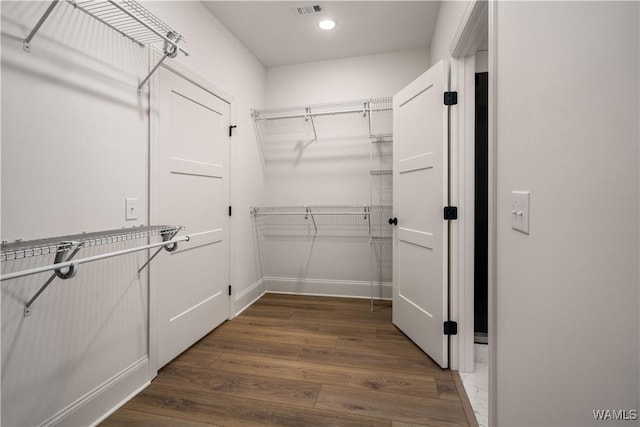 spacious closet featuring dark hardwood / wood-style floors