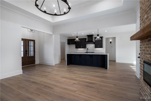 kitchen featuring dark wood-type flooring, a fireplace, a chandelier, and premium range hood