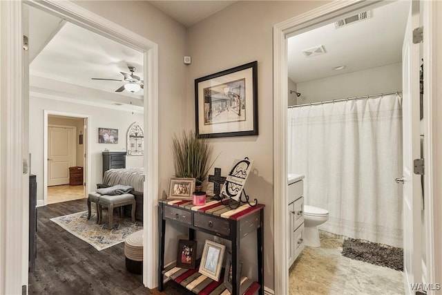 bathroom featuring visible vents, ceiling fan, toilet, and wood finished floors