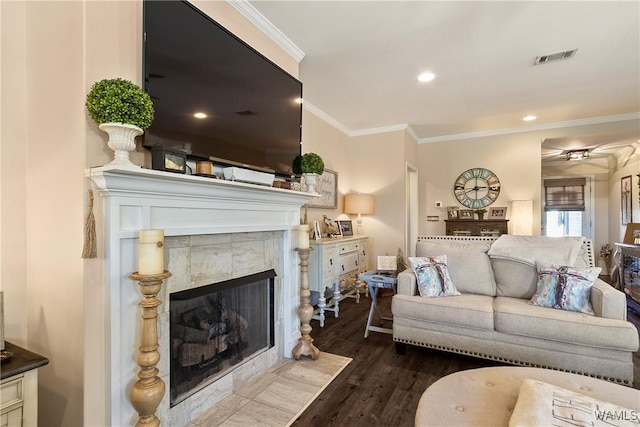 living area featuring a fireplace, recessed lighting, visible vents, ornamental molding, and wood finished floors