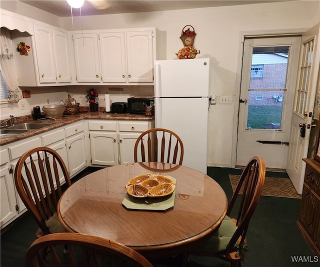 kitchen featuring white cabinets, white refrigerator, and sink