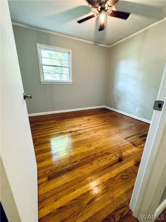 unfurnished room with hardwood / wood-style floors, a textured ceiling, and crown molding