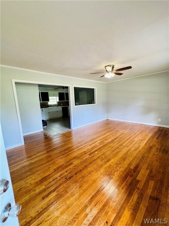 empty room with ceiling fan, hardwood / wood-style floors, and a textured ceiling