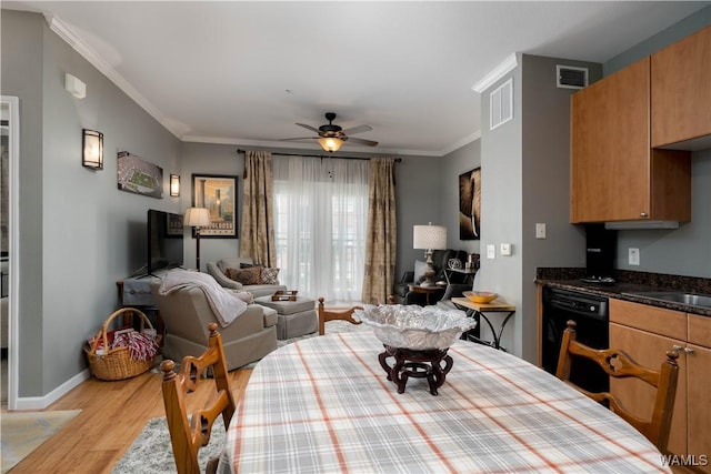 dining space with ceiling fan, visible vents, baseboards, ornamental molding, and light wood-style flooring