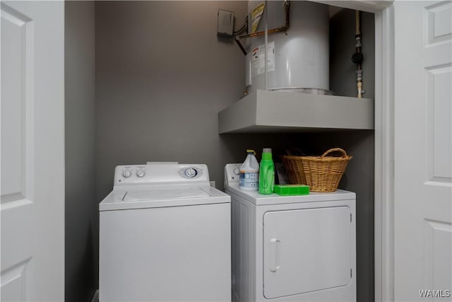 washroom with laundry area, independent washer and dryer, and water heater