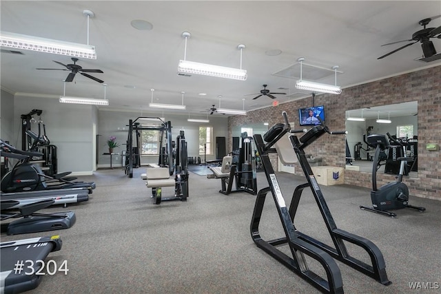 gym with baseboards, ceiling fan, brick wall, and visible vents