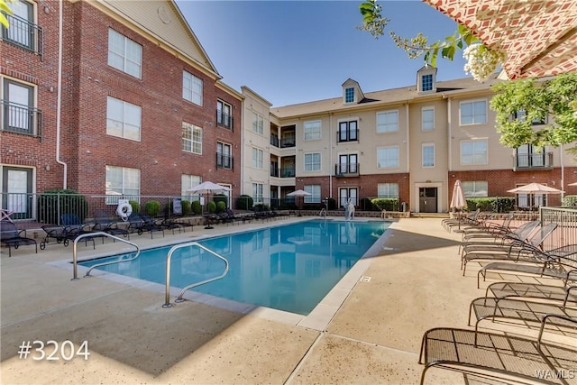community pool featuring fence and a patio area
