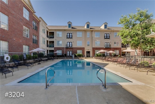 pool with a patio and fence