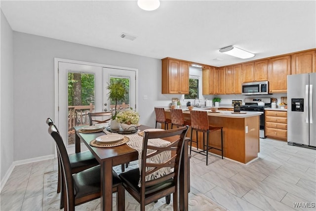 kitchen featuring french doors, a breakfast bar, sink, appliances with stainless steel finishes, and kitchen peninsula