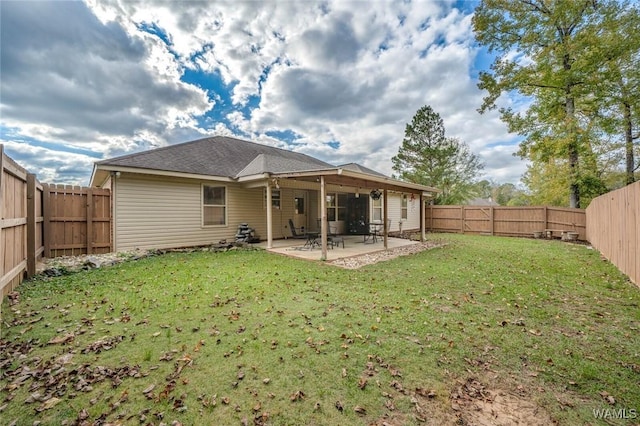 back of property with a patio area, a fenced backyard, and a lawn