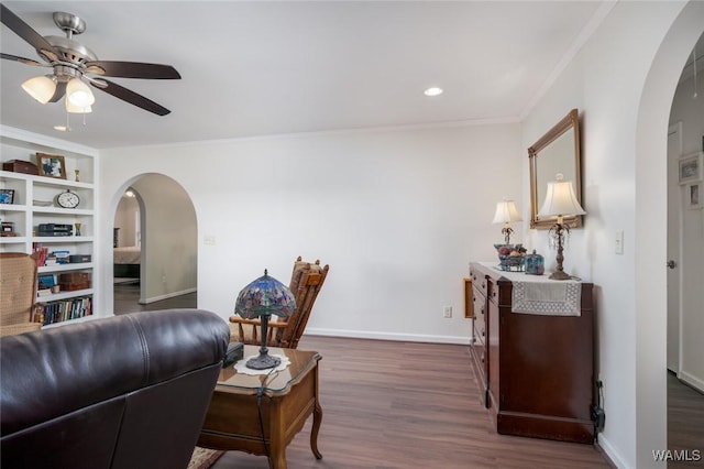 interior space with arched walkways, ceiling fan, dark wood-style flooring, and crown molding