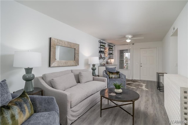 living room with ceiling fan and wood-type flooring