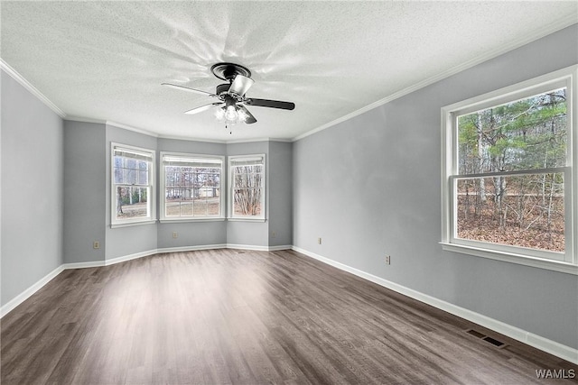 spare room featuring crown molding, visible vents, a textured ceiling, wood finished floors, and baseboards