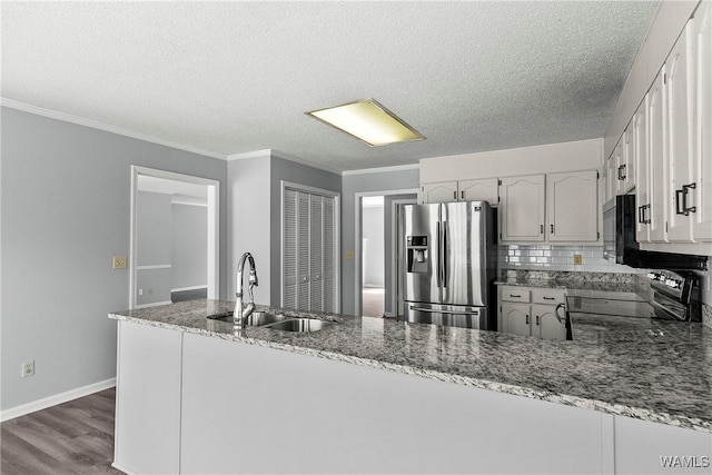 kitchen featuring range, white cabinetry, a sink, and stainless steel fridge with ice dispenser