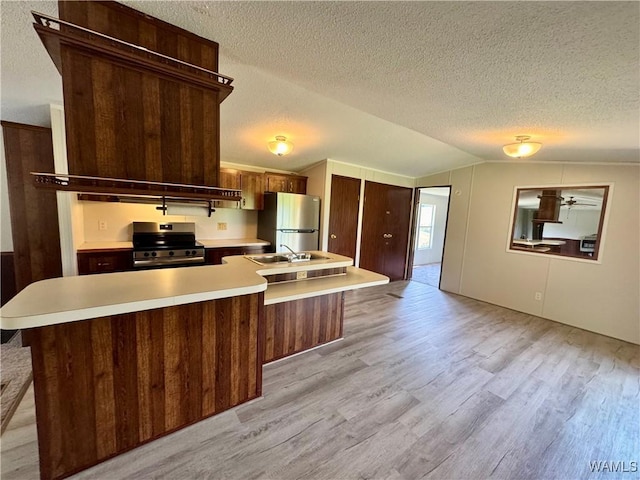 4247 W Ashby Rd, Brierfield, AL 35035 - kitchen featuring appliances with stainless steel finishes, a textured ceiling, light wood-type flooring, light countertops, and vaulted ceiling