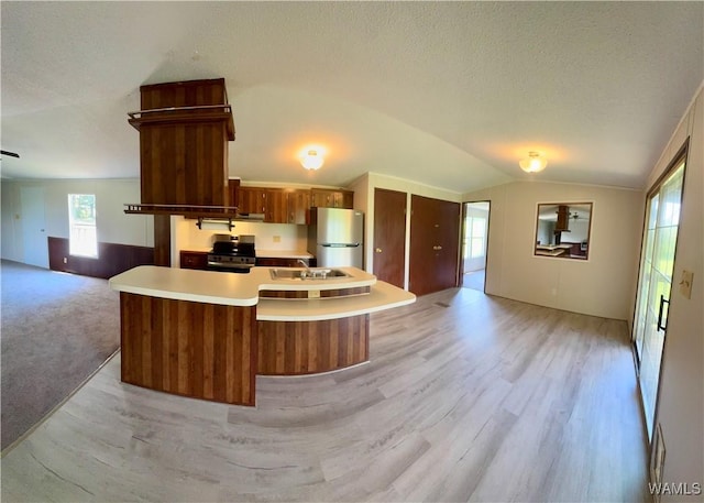 4247 W Ashby Rd, Brierfield, AL 35035 - kitchen with freestanding refrigerator, open floor plan, stainless steel range with electric stovetop, vaulted ceiling, and light wood-style flooring
