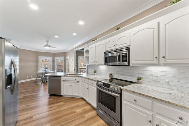 20892 Sharon Dr, Lake View, AL 35111 - kitchen with a peninsula, ornamental molding, appliances with stainless steel finishes, white cabinetry, and a sink