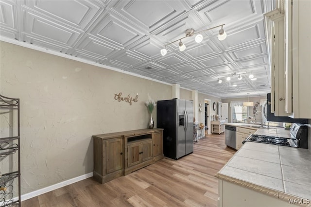20892 Sharon Dr, Lake View, AL 35111 - kitchen with a textured wall, an ornate ceiling, baseboards, light wood finished floors, and appliances with stainless steel finishes