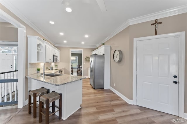 20892 Sharon Dr, Lake View, AL 35111 - kitchen featuring white cabinetry, a peninsula, a sink, and stainless steel appliances