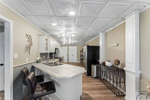 20892 Sharon Dr, Lake View, AL 35111 - kitchen with an ornate ceiling, a sink, freestanding refrigerator, light wood-style flooring, and white cabinets