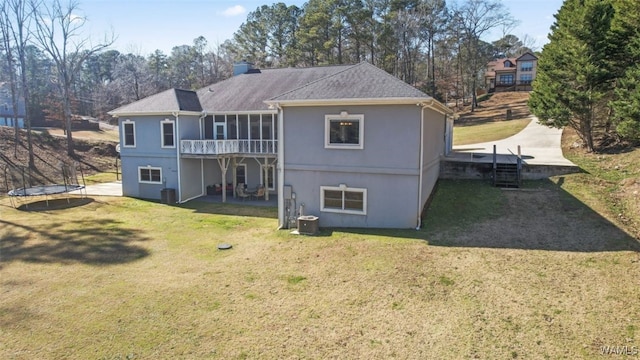 20892 Sharon Dr, Lake View, AL 35111 - back of house featuring a trampoline, roof with shingles, central AC unit, and a yard