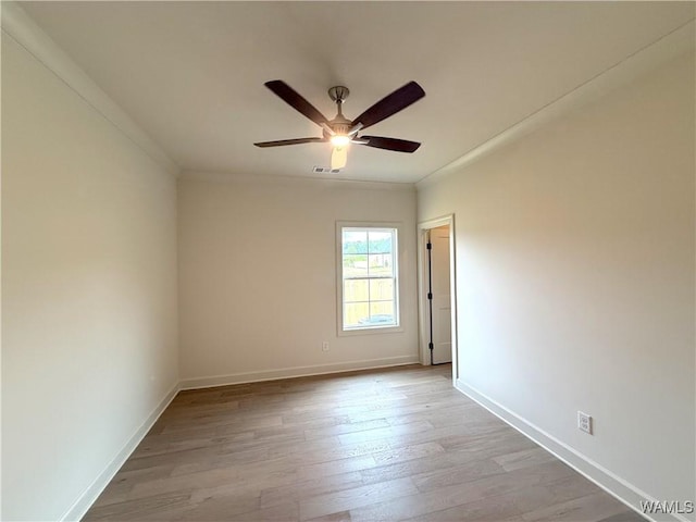 empty room featuring crown molding, wood finished floors, visible vents, and a ceiling fan